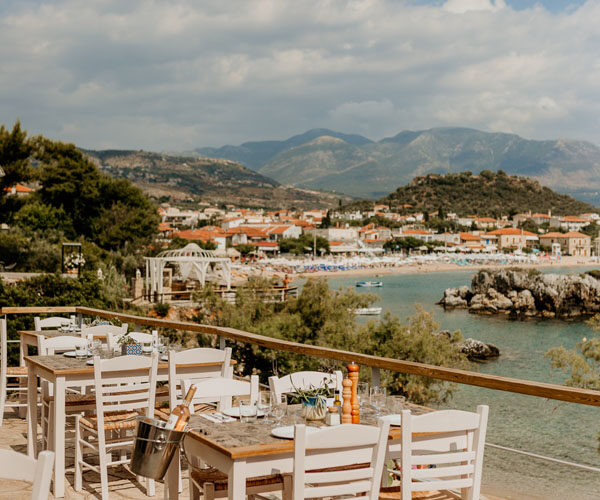 Morning terrace tables at Enigma cafe overlooking Stoupa bay and the Messenian Gulf