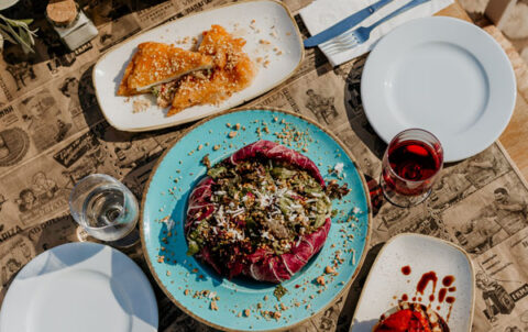 Meze plates, bread and wine on the terrace table at Liastres restaurant in Stoupa