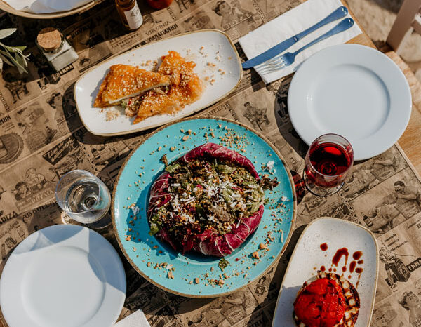 Meze plates, bread and wine on the terrace table at Liastres restaurant in Stoupa