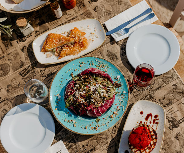Meze plates, bread and wine on the terrace table at Liastres restaurant in Stoupa